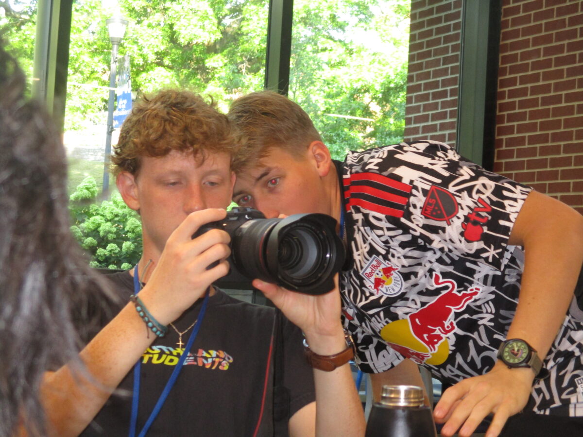 Cody Spivey and Atherton student Zaxton Rothberg (12) look over photos from the previous week at GSA.