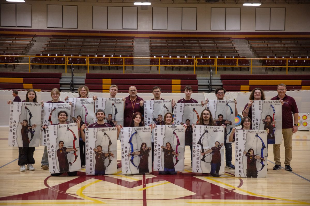 Seniors on the archery team pose with their senior banners. 
